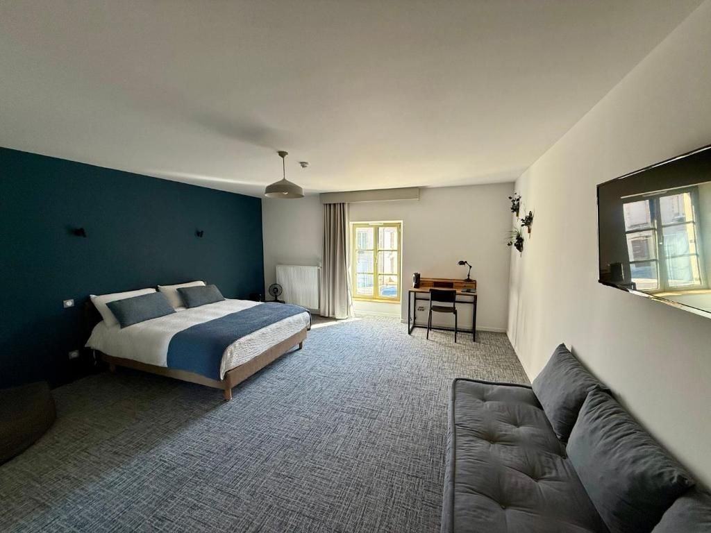 Quarto com cama, escrivaninha, cadeira e janela.