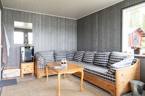 A cozy room with a wooden sofa, a wooden table, and a television.