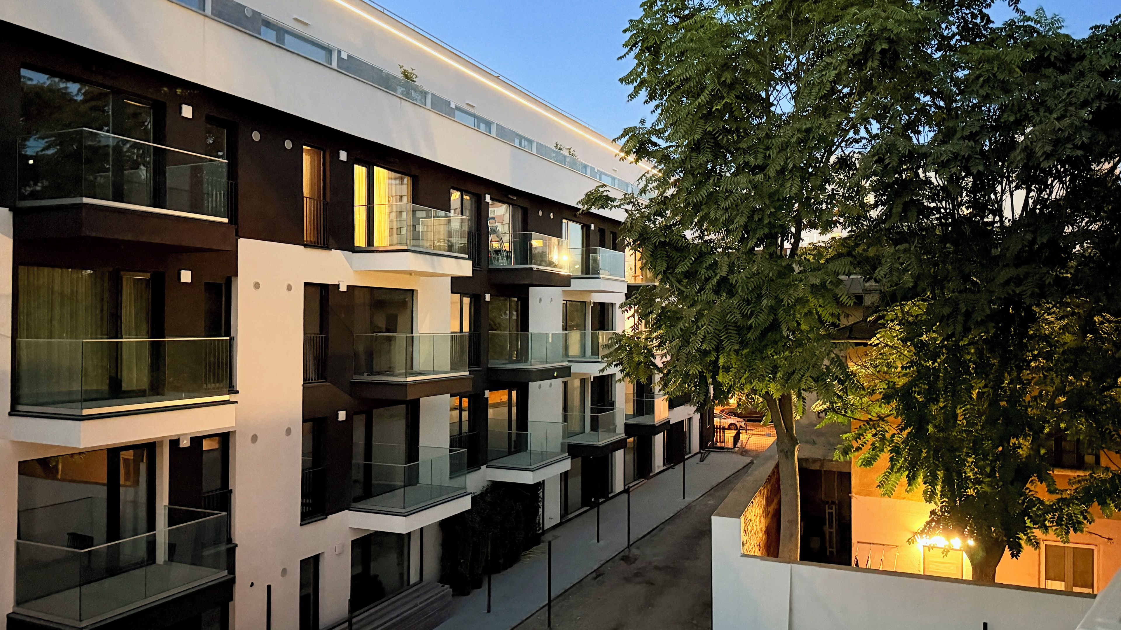 A multi-story building with balconies and large windows.