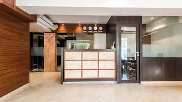 A reception area with a marble floor, a reception desk, and clocks indicating different time zones.