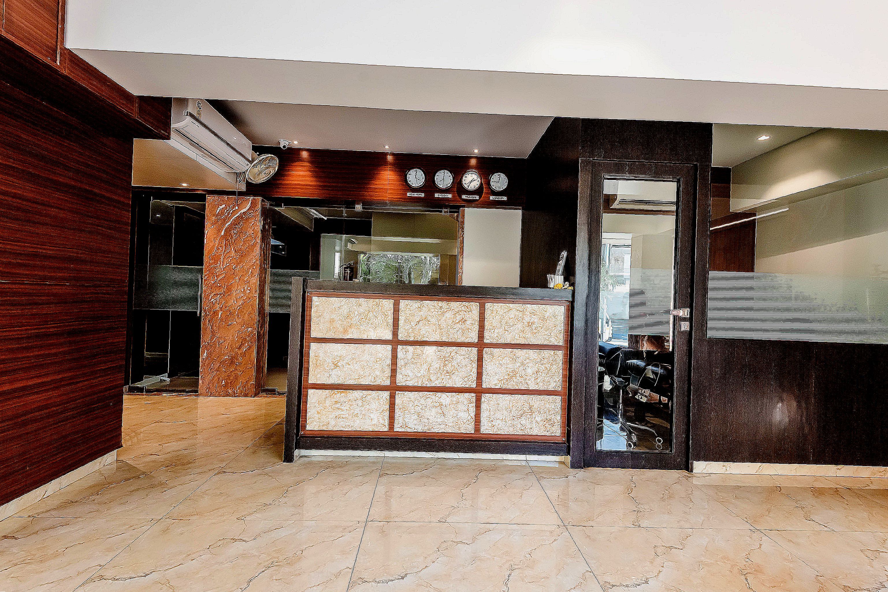 A reception area with a check-in counter, a clock above it, and a tiled floor.