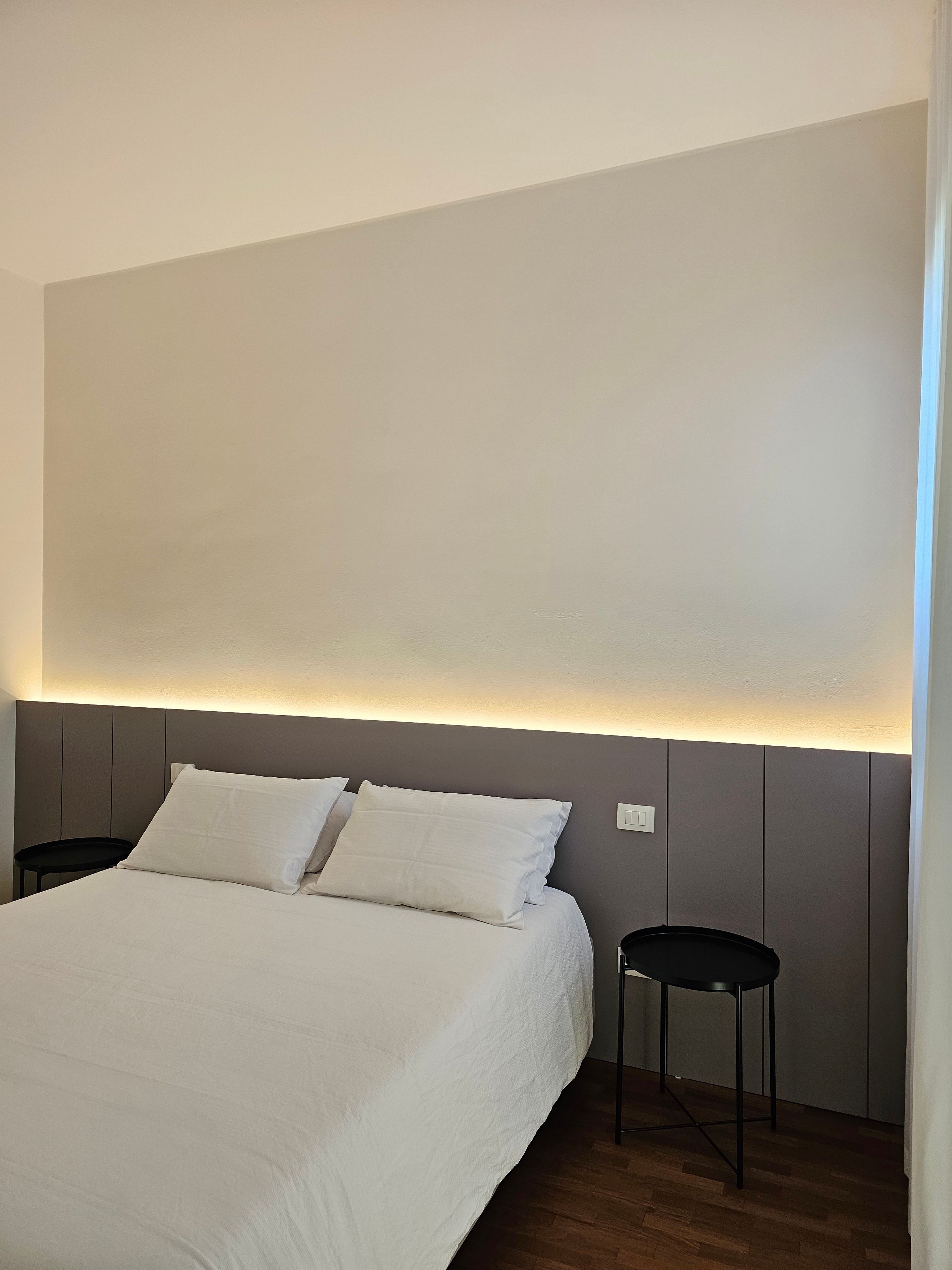 Ein Hotelzimmer mit einem großen Bett, einem Nachttisch und einer Wandleuchte.