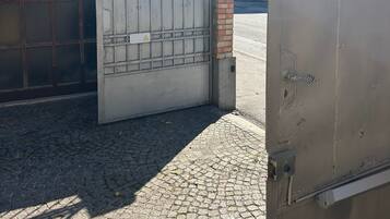 A gated entrance with a metal gate and a brick pillar.