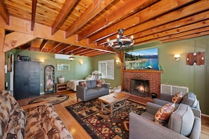 A cozy living room with a fireplace, a sofa, a coffee table, and a rug.