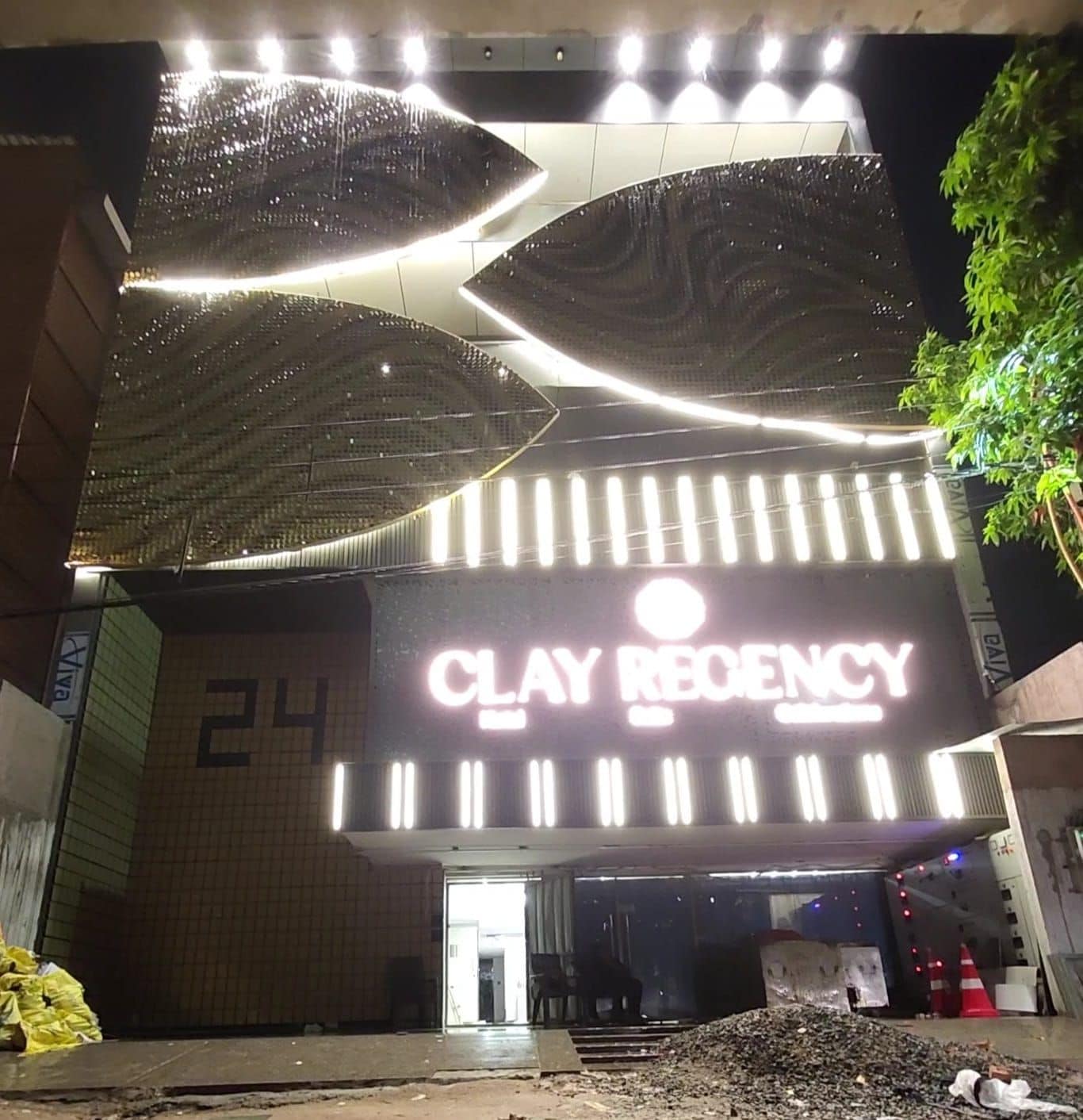 A building with a large illuminated sign reading 'CLAY REGENCY' and a number '24' on the wall.