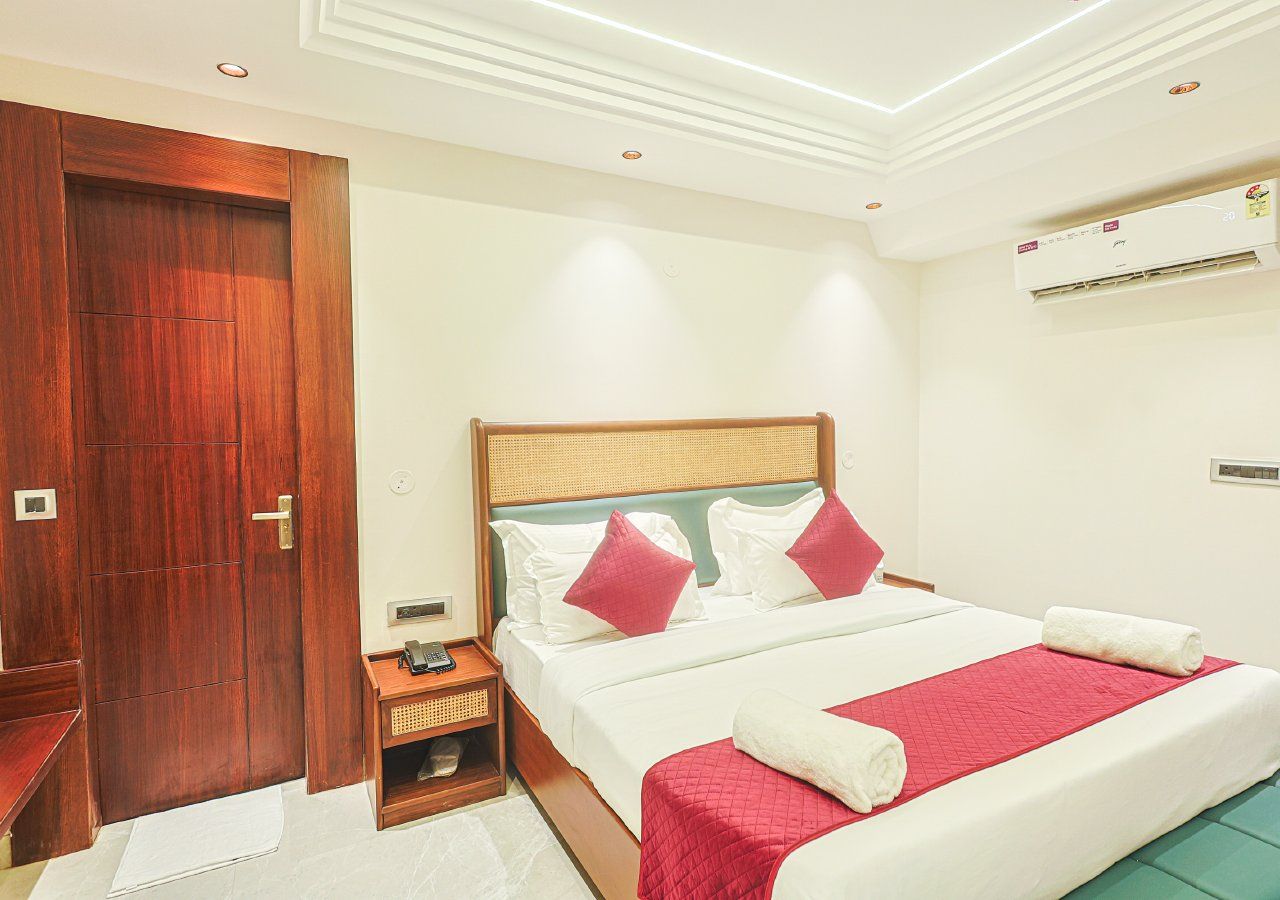 A hotel room with a bed, bedside table, and a wardrobe.