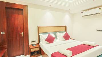 A hotel room with a bed, bedside table, and a wardrobe.
