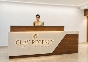 Moderne receptionsdisk på Clay Regency Hotel, med hotellets logo og navn.