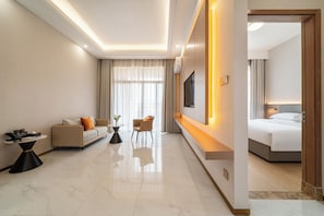 A modern hotel room with a sofa, armchair, bedside table, and a bed. - Poltton International ApartmentsQingyuan (Qingyuan)