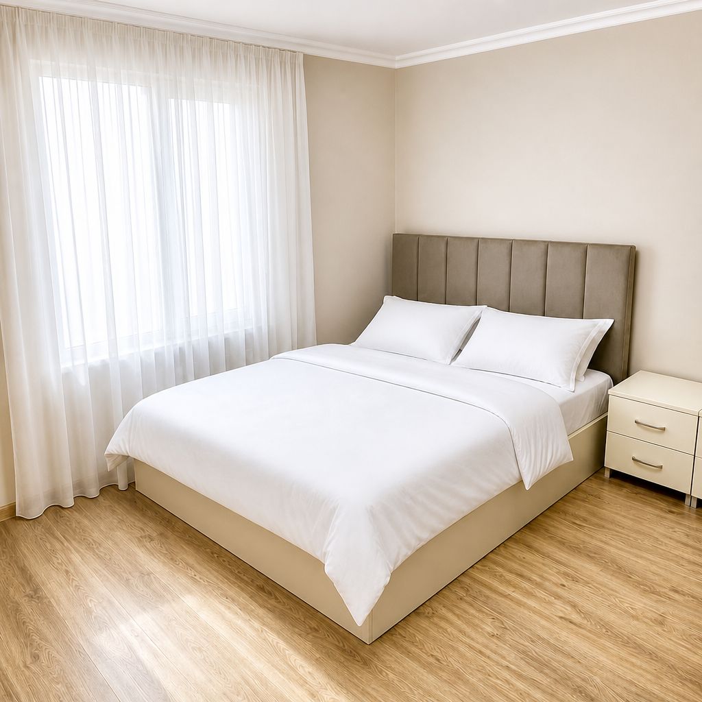 Une chambre à coucher avec un lit, une table de chevet et une fenêtre avec des rideaux.
