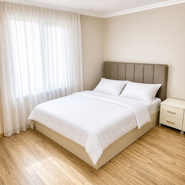 Una camera da letto con un letto, un comodino e una finestra con tende.