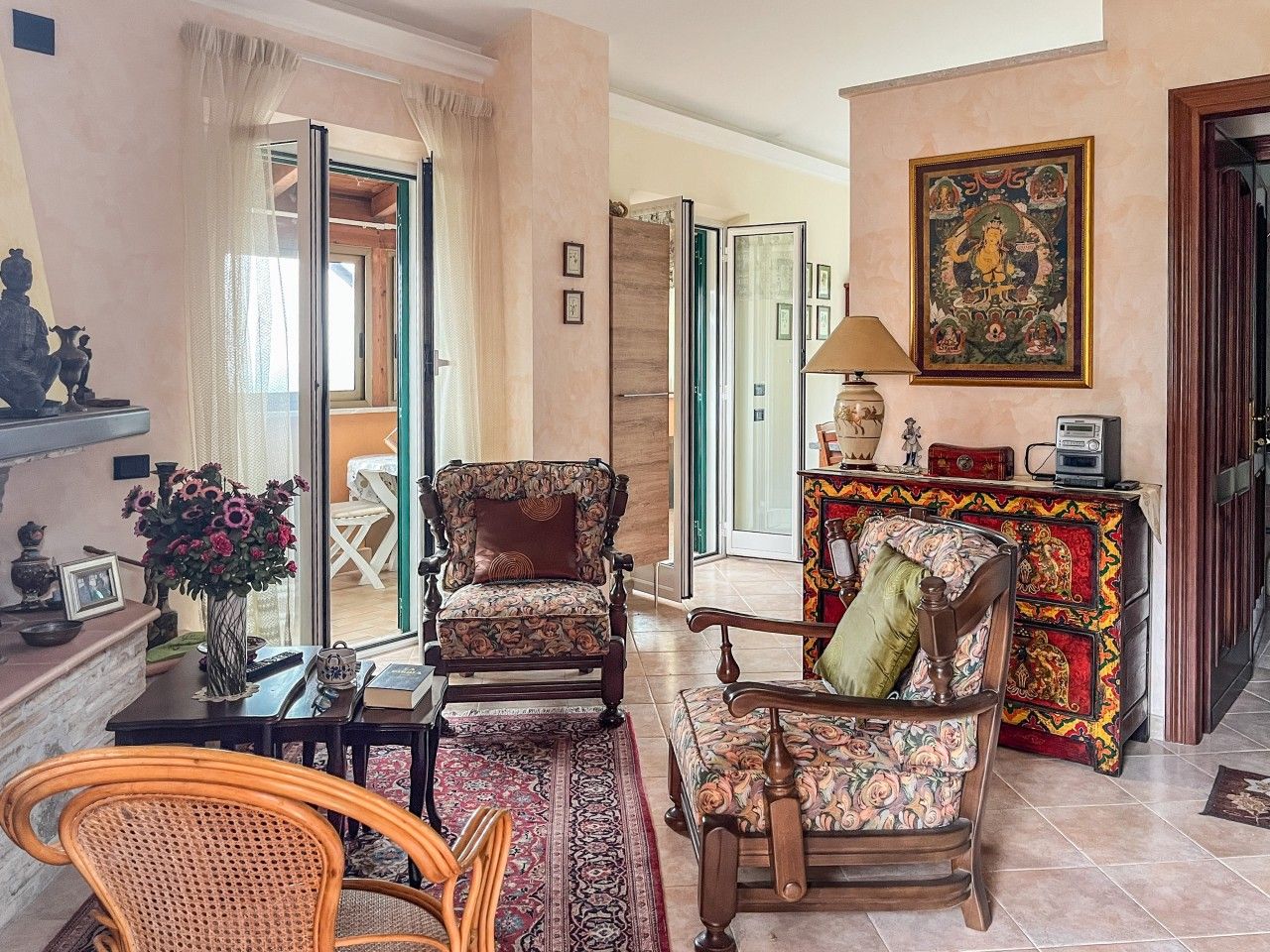 A traditional living room with a sofa, armchairs, a coffee table, and a fireplace.