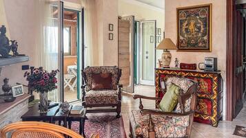 A traditional living room with a sofa, armchairs, a coffee table, and a fireplace.