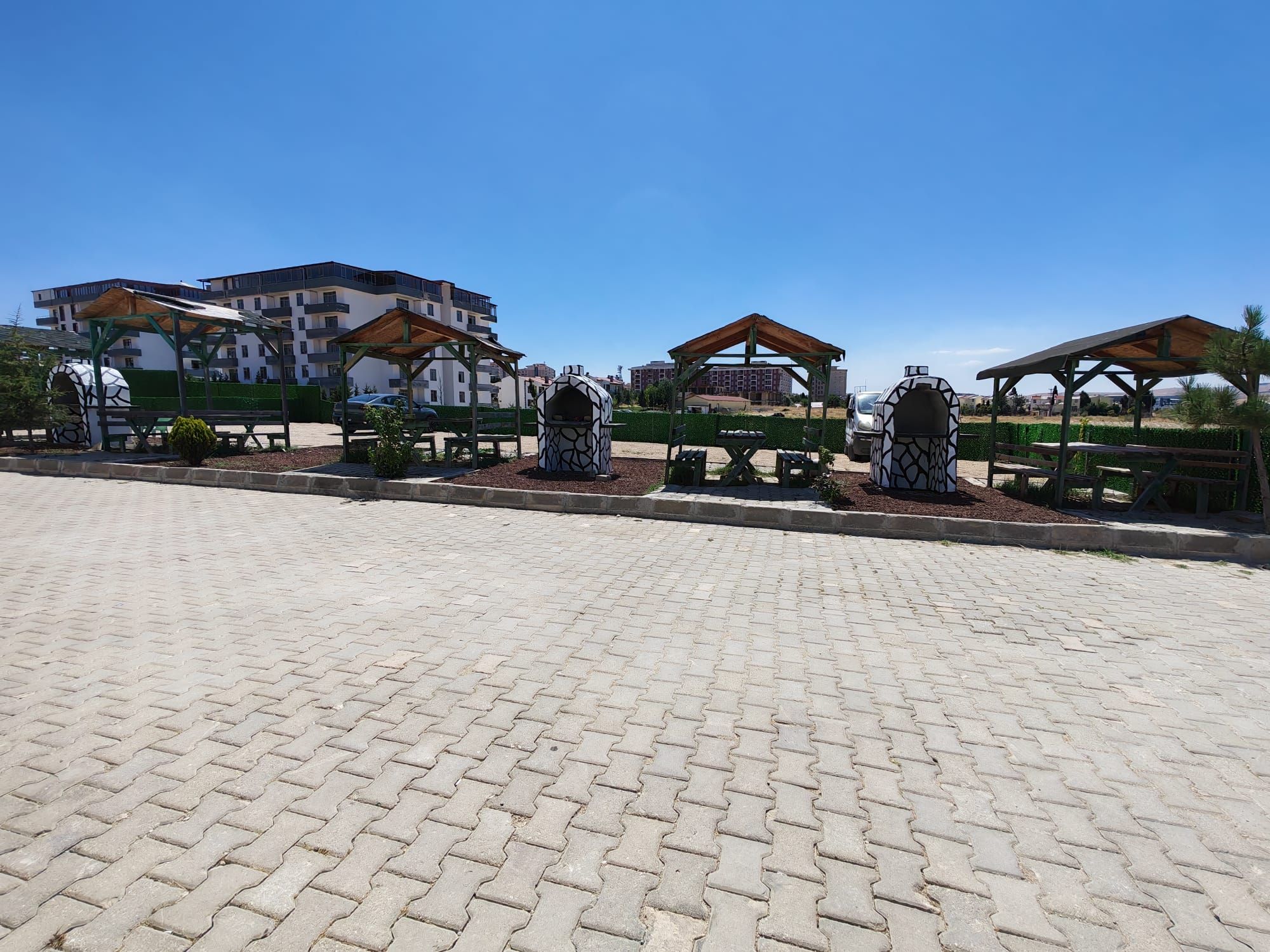 A paved area with outdoor seating and a building in the background.
