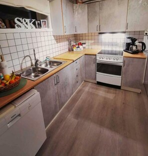 A kitchen with a sink, stove, and cabinets. - Northern Lights Apt Midtgaard · 2BR · Free Parking · Kvaløya Tromsø (Tromsø)