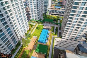 A high-rise residential building with multiple floors, a rooftop garden, and a blue swimming pool. - Stylish 2BR at GTC | Walk to Mall & Offices (Nairobi)