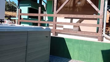 A building with a green exterior and a wooden structure in front.