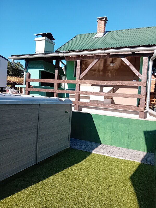 A building with a green exterior and a wooden structure in front.