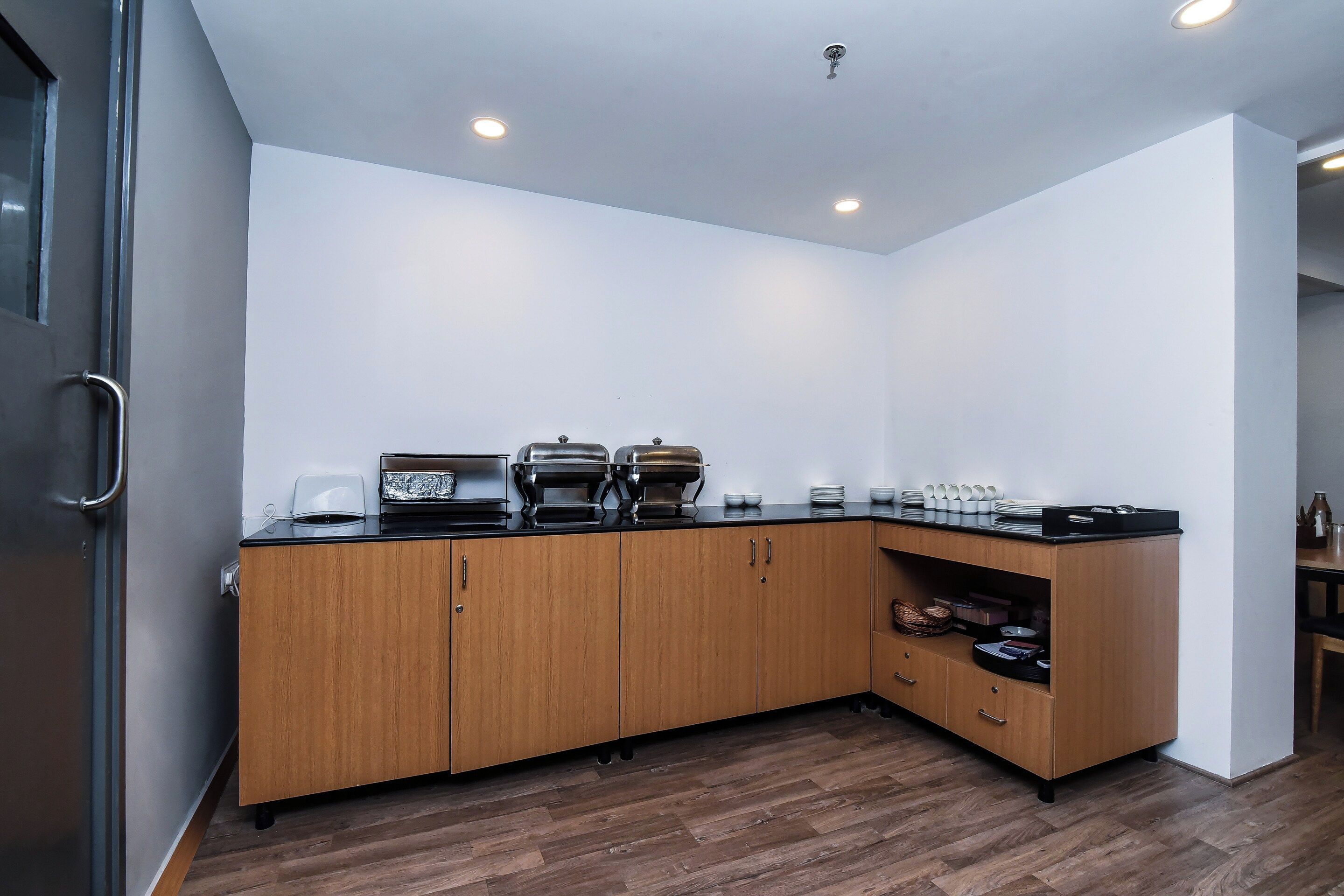 A modern kitchen with wooden cabinets, a black countertop, and built-in appliances.