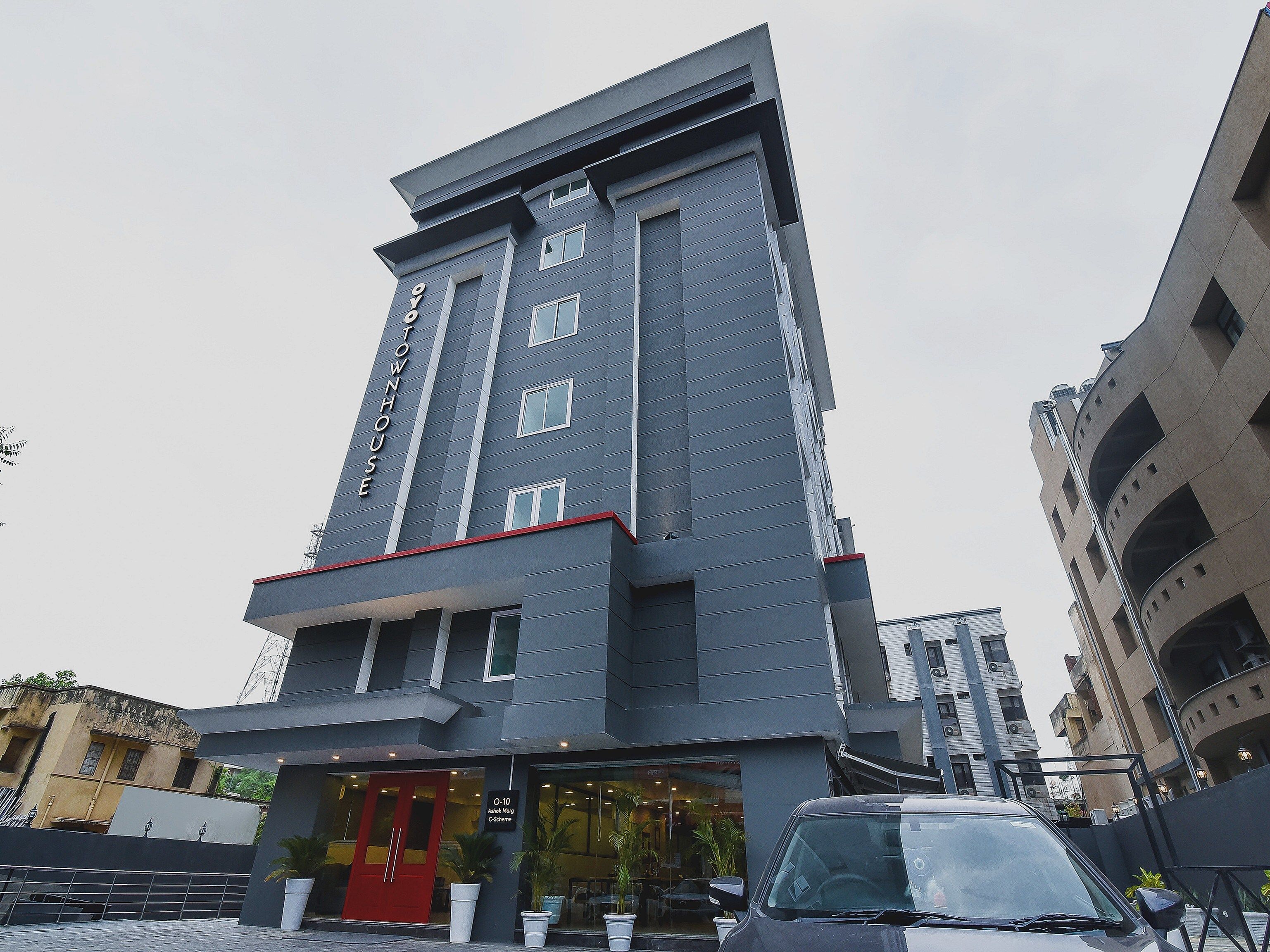 A modern hotel with a prominent entrance, multiple floors, and a clear sky.