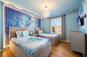 A bedroom with two beds, a chandelier, and a television. - Newly Furnished 10BR | South Pool & Spa | Games (Davenport)