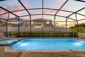 A swimming pool with a covered area, surrounded by a fence, and a view of a building in the background. - Newly Furnished 10BR | South Pool & Spa | Games (Davenport)