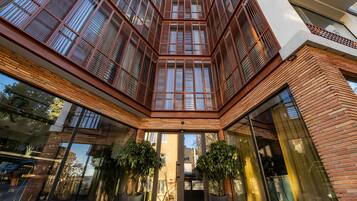 Un bâtiment moderne doté d’une cour intérieure, de grandes fenêtres et de plantes en pot.