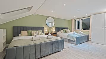 A modern bedroom with two beds, a large mirror, and a sliding glass door.