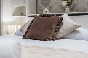 A bed with a brown pillow and a white pillow. - Willowtree (Liverpool)