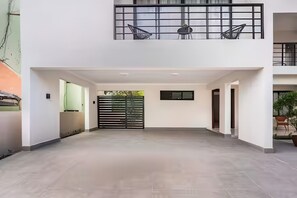 Een ruim, modern interieur met een grote open ruimte, een balkon met stoelen en een afsluitbaar hek.