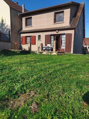 A two-story house with a front porch and a grassy yard. - Country Living: A Country House Furnished in a Traditional Style, Near a River and Forest (Malay-le-Grand)