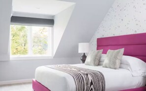 Un dormitorio con cama, ventana y pared con un diseño.