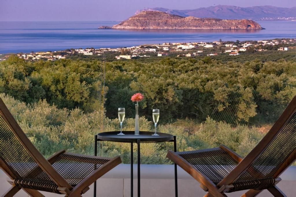 Eine Terrasse mit zwei Liegestühlen und einem Tisch mit zwei Sektgläsern.