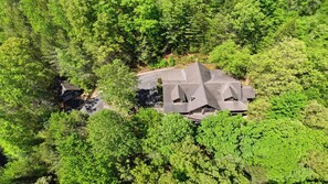 An aerial view of a house surrounded by dense forest. - Timberstone: Luxury 4BR Cabin, Pool table, Arcade, Hot Tub, & Resort Pool (Sevierville)