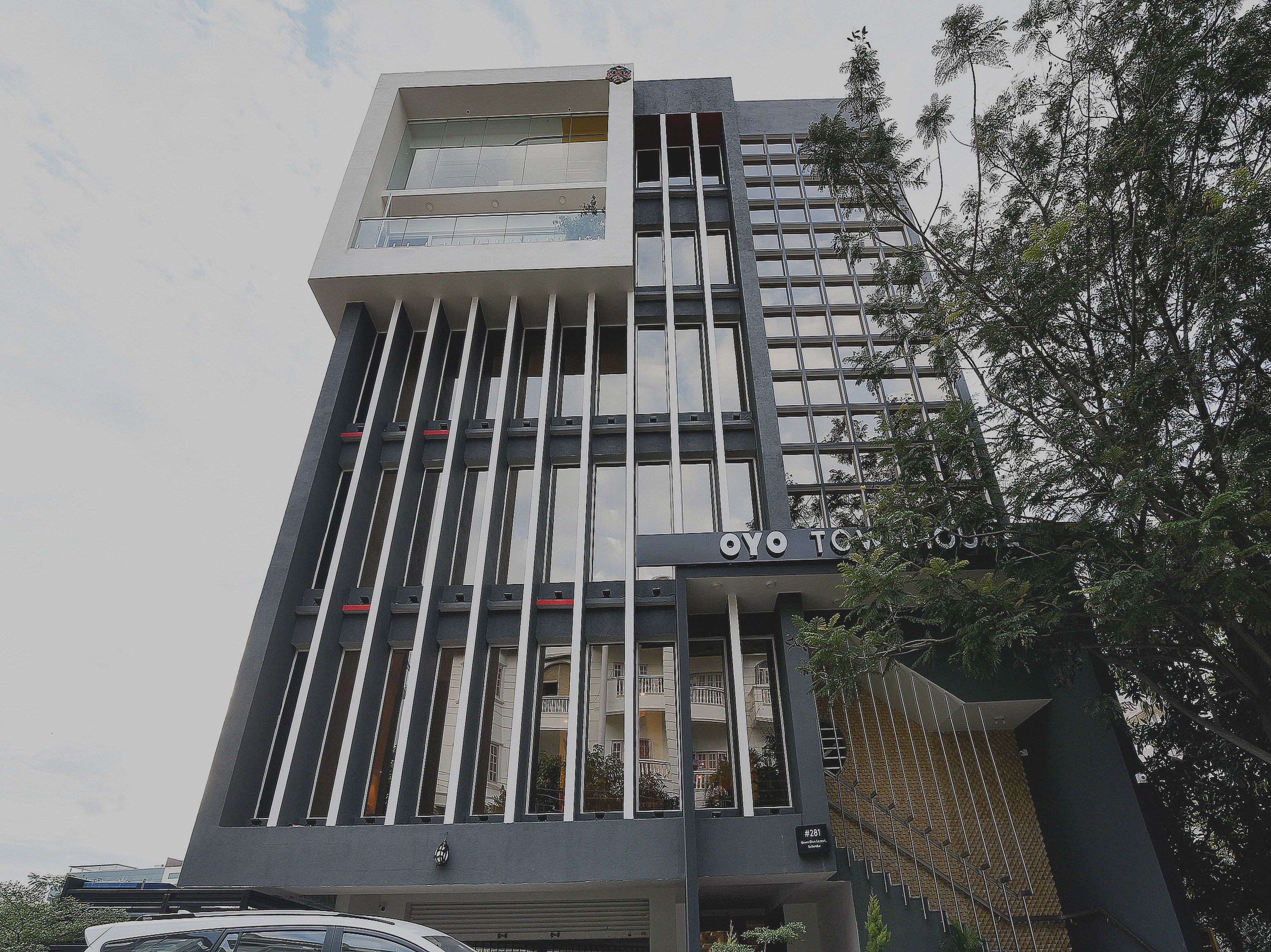 A modern building with a prominent vertical design, featuring a series of windows and a balcony on the upper floor.