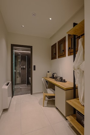 A modern bathroom with a shower, toilet, and a small kitchenette area. - Elysian Castle (Ioannina)