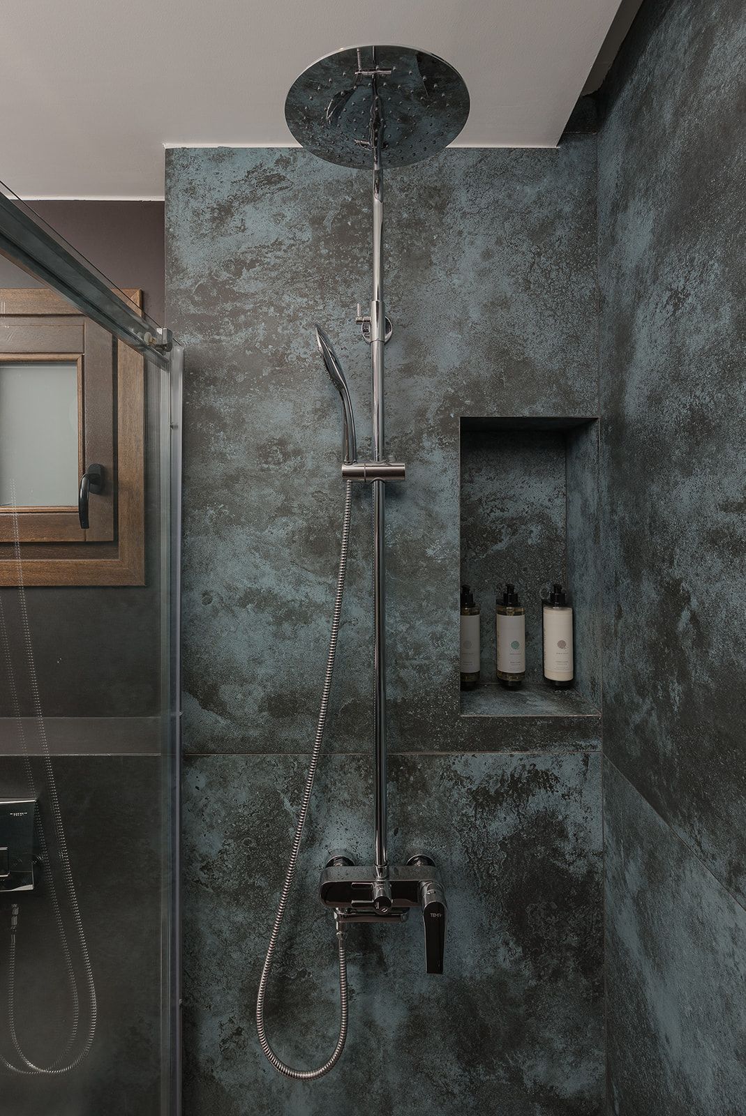 Un baño moderno con ducha lluvia, ducha de mano y cabezal de ducha manual.