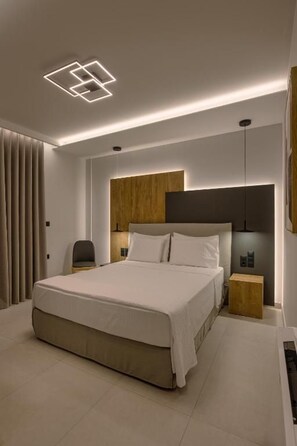 Ein modernes Schlafzimmer mit einem großen Bett, Nachttischen, einer Kopfteil und einer Deckenleuchte.