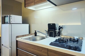 A modern kitchen with a built-in microwave, a gas stove, and a stainless steel sink. - HOTEL SOVA Kumamoto Suido-cho (Kumamoto)