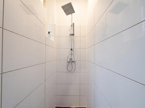 A shower area with a handheld showerhead and a fixed overhead showerhead. - Your Vienna Chapter 1BR near Westbahnhof (Vienna)