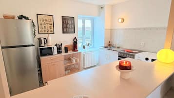 Eine moderne Küche mit Kühlschrank, Mikrowelle, Herd und einem Fenster.
