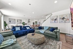 A modern living room with a sofa set, a round coffee table, and artwork on the walls. - The Trilogy: 27 Bedroom/18Bath/Sleeps 60/LazyRiver/Pickleball/GameRoom (Coachella)