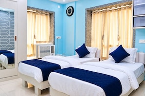 Ein Hotelzimmer mit zwei Betten, einer Wanduhr und einem Vorhangfenster.