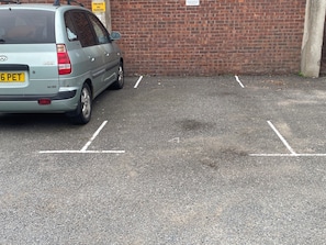 Un área de estacionamiento con un automóvil estacionado en un espacio delimitado.