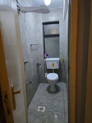 A small bathroom with a toilet, a shower, and a sink. - Enjoyable 1-bedroom apartment in lovely Nairobi neighborhood (Nairobi)