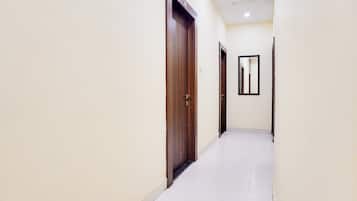 A corridor with wooden doors and a tiled floor.