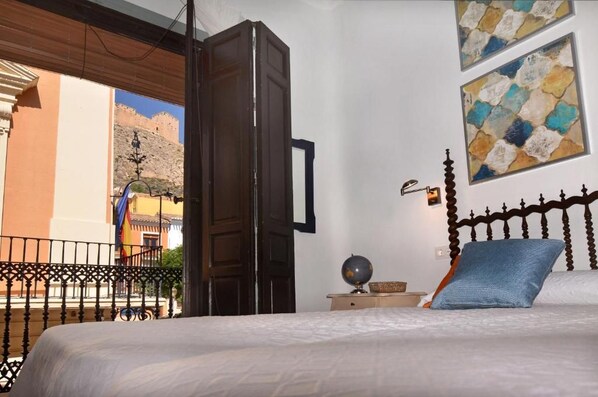 A hotel room with a bed, a nightstand, a globe, and artwork on the wall.