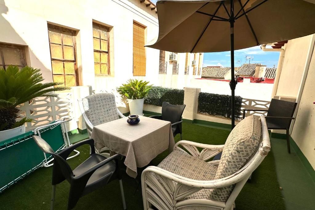 An outdoor patio with a table, chairs, and an umbrella.