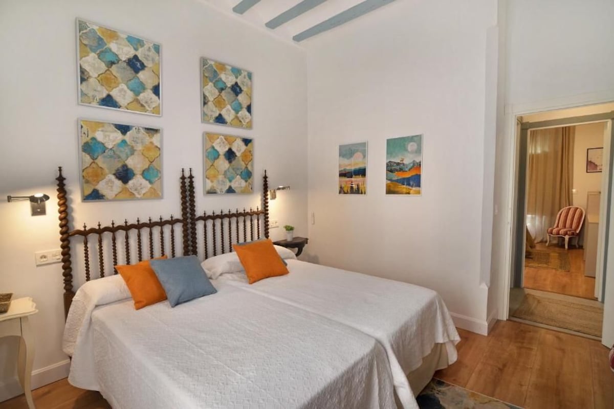 Een slaapkamer met een bed, een nachtkastje en wanddecoratie.