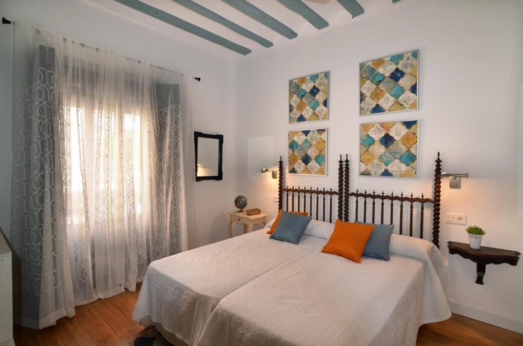 A double bed with a headboard, two bedside tables, and a wall-mounted lamp.